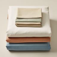 Coordinated duvet cover, fitted sheet, and pillowcases folded together as a bed linen set