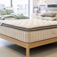 Layered pocket-sprung mattress displayed in a bright Isle of Wight bedroom showroom